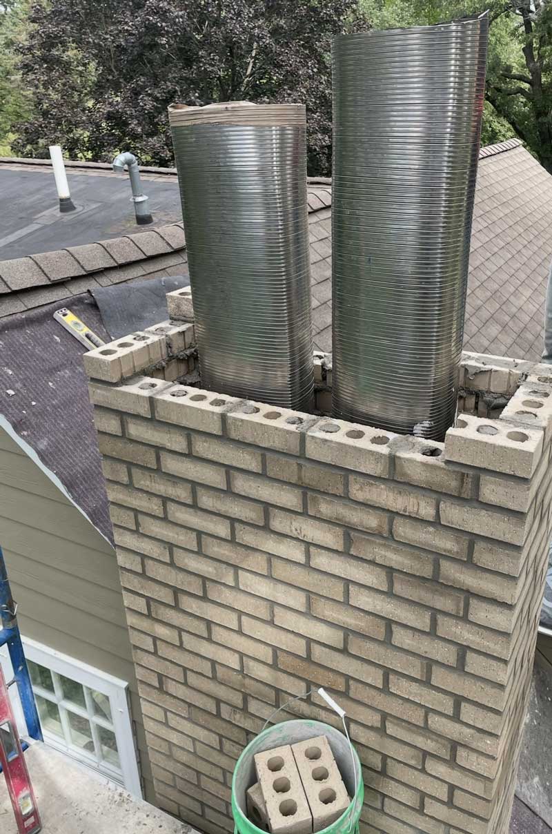 Brick chimney with two metal flue liners